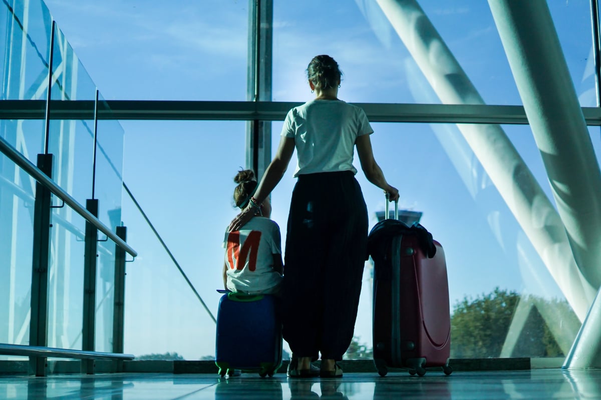 Passengers with luggage in a bright airport terminal waiting for their flight