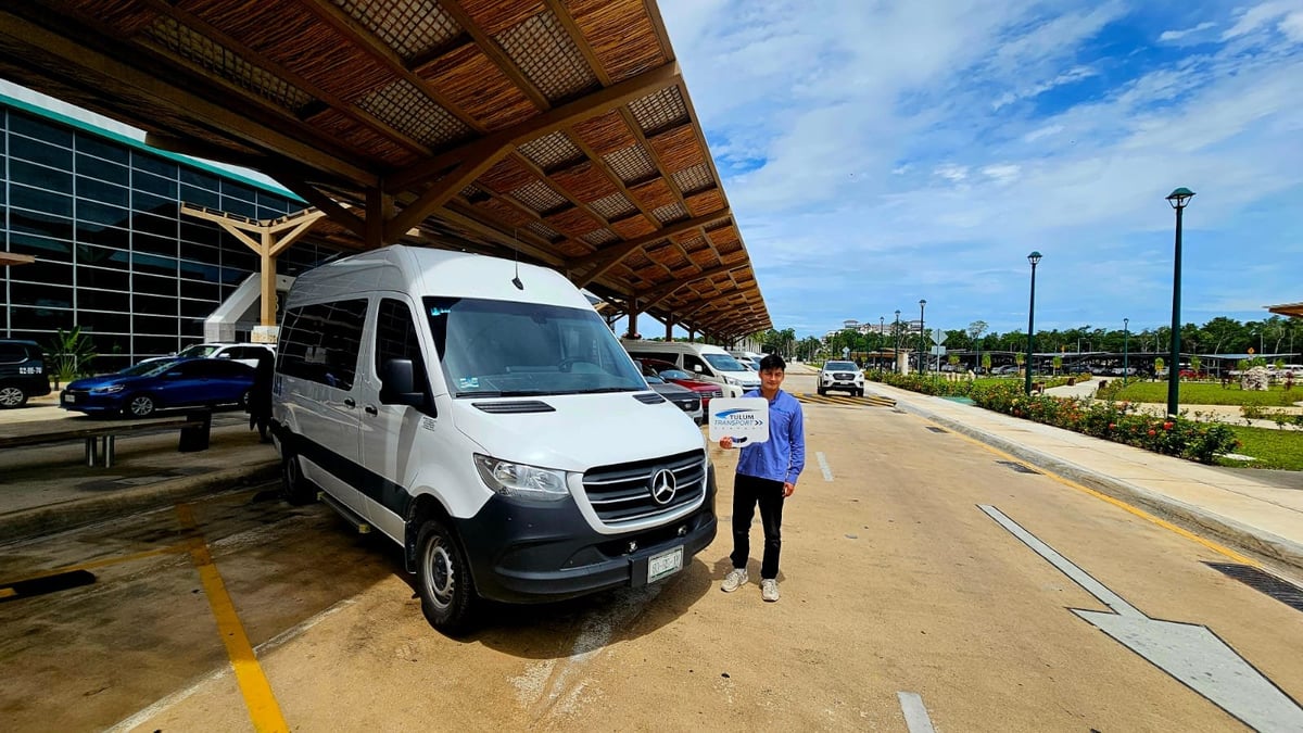 Conductor de TTC con una van de traslado privado en el Aeropuerto Internacional de Tulum (TQO)